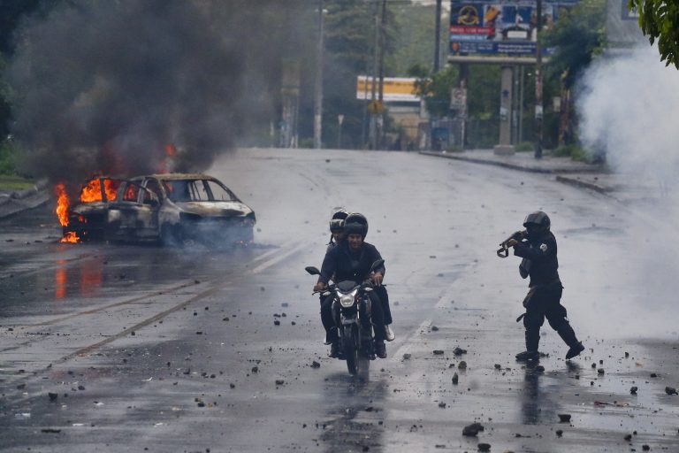 AP Photo,Un policía apunta un fusil a dos hombres en una motocicleta durante una protesta contra el presidente Daniel Ortega en Managua, Nicaragua, el lunes 28 de mayo de 2018. (AP Foto/Esteban Félix)
