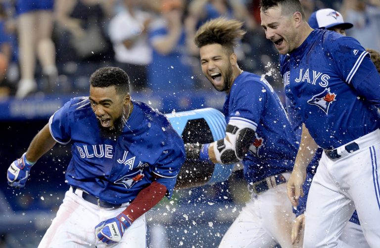 AP Photo,Teoscar Hernández (37) de los Azulejos de Toronto es bañado por sus compañeros tras conectar un jonrón en el 12do inning para la victoria ante los Rays de Tampa Bay, el sábado 27 de julio de 2019. (Nathan Denette/Canadian Press via AP)