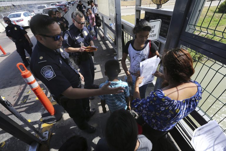 AP Photo,Foto de archivo del 17 de julio de 2019 de un agente fronterizo estadounidense verificando los documentos de migrantes antes de ser llevados a solicitar asilo en Estados Unidos, en el Puente Internacional 1 en Nuevo Laredo, México. (Foto AP/Marco Ugarte, Archivo)