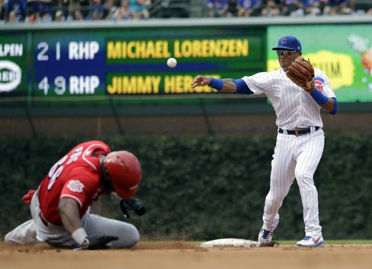 AP Photo, Addison Russell, Yasiel Puig,El segunda base de los Cachorros de Addison Russell (derecha) tira a primera base tras sacar out en segunda a Yasiel Puig de los Rojos de Cincinnati, el miércoles 17 de julio de 2019. (AP Foto/Nam Y. Huh)