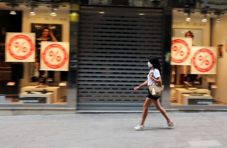 LYNXNPEG6F1ML.jpg,FOTO DE ARCHIVO: Una mujer con mascarilla camina frete a una tienda cerrada en Lleida, Cataluña, España, el 13 de julio de 2020. REUTERS/Nacho Doce; Crédito: NACHO DOCE, Reuters