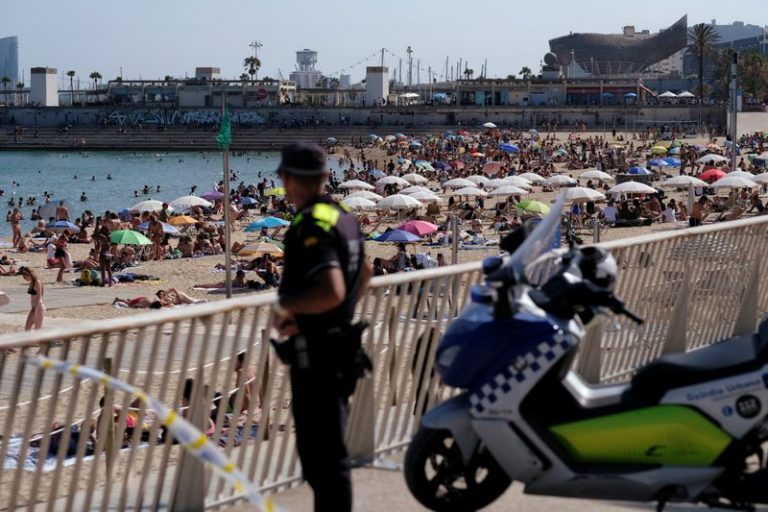 LYNXNPEG6Q18R.jpg,Foto de archivo de un policía mirando al público que disfruta de un día de playa en Barcelona. 
Jun 21, 2020. REUTERS/Nacho Doce; Crédito: Nacho Doce, Reuters