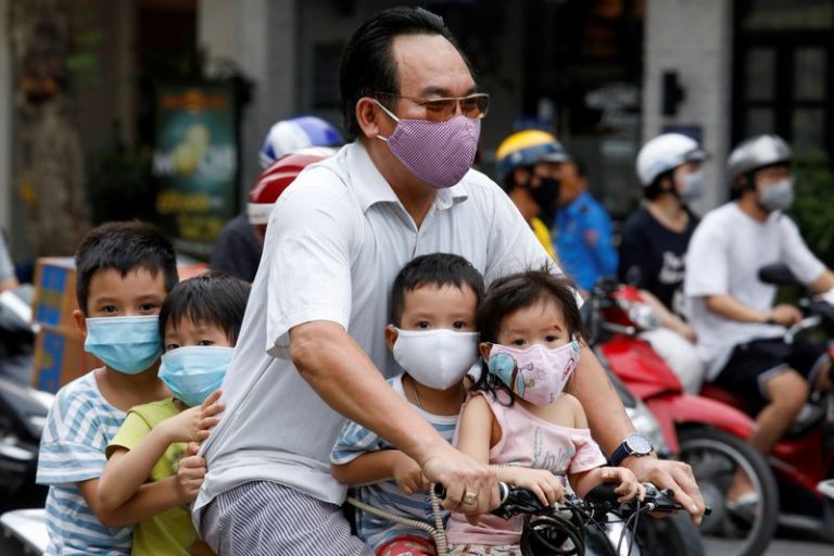 LYNXMPEG7L0E7.jpg,Imagen de archivo de un hombre y sus hijos con mascarillas andando con bicicleta por Hanói, Vietnam. 27 julio 2020. REUTERS/Kham; Crédito: Kham, Reuters