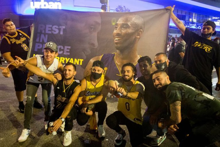 LYNXMPEG9B0XB.jpg,Aficionados de los Lakers celebran que su equipo haya ganado el campeonato de la NBA del 2020, posando con una bandera de Kobe Bryant, durante la pandemia de COVID-19 en Los Ángeles, California, Estados Unidos. 11 de octubre de 2020.  REUTERS/Ringo Chiu ; Crédito: Ringo Chiu, Reuters