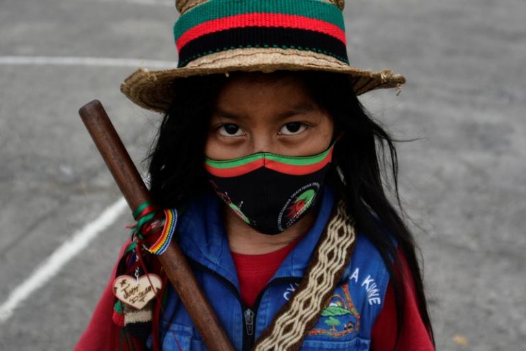 LYNXMPEG9E1JS.jpg,Una niña indígena posa para una foto en una protesta para pedir al gobierno colombiano seguridad en sus territorios, el fin de las masacres y asesinatos de líderes sociales, durante un encuentro indígena denominado 