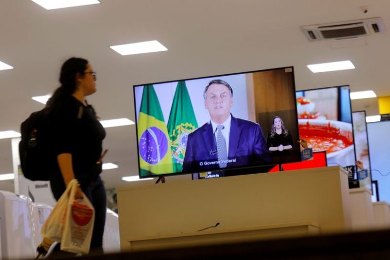 LYNXMPEG9S15V.jpg,FOTO DE ARCHIVO. Una mujer pasa junto a una transmisión por televisión de la declaración del presidente de Brasil, Jair Bolsonaro, sobre el coronavirus, en una tienda en Brasilia, Brasil. 6 de marzo de 2020. REUTERS/Adriano Machado; Crédito: ADRIANO MACHADO, Reuters