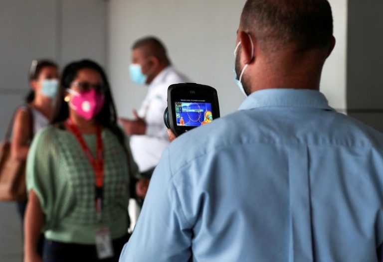 LYNXMPEG9S18A.jpg,FILE PHOTO: An employee measures the temperatures of travelers at the Tocumen International Airport during the coronavirus disease (COVID-19) outbreak, in Panama City, Panama October 16, 2020. Picture taken October 16, 2020. REUTERS/Erick Marciscano/File Photo; Crédito: ERICK MARCISCANO, Reuters