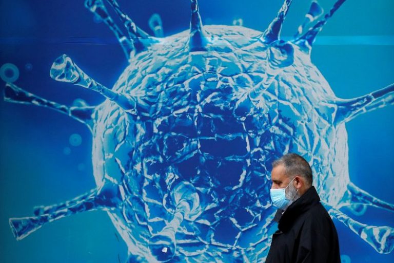 LYNXMPEG9S1KS.jpg,FILE PHOTO: A man wearing a protective face mask walks past an illustration of a virus outside a regional science centre, as the city and surrounding areas face local restrictions in an effort to avoid a local lockdown being forced upon the region, amid the coronavirus disease (COVID-19) outbreak, in Oldham, Britain August 3, 2020. REUTERS/Phil Noble; Crédito: PHIL NOBLE, Reuters