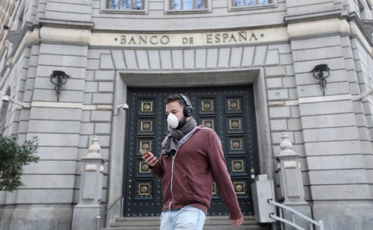 LYNXMPEG9S1LV.jpg,FOTO DE ARCHIVO. Un hombre con mascarilla pasa frente un edificio del Banco de España, en Barcelona, España. 14 de marzo de 2020. REUTERS/Nacho Doce; Crédito: Nacho Doce, Reuters