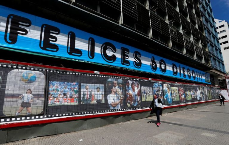LYNXMPEG9T1QM.jpg,Imagen del día de personas caminando frente a un cartel en homenaje al exastro del fútbol argentino Diego Maradona por la celebración de su cumpleañños número 60, cerca del Obelisco, en Buenos Aires, Argentina. Octubre 30, 2020. REUTERS/Agustin Marcarian; Crédito: AGUSTIN MARCARIAN, Reuters