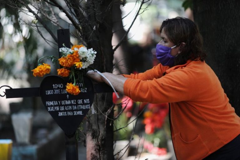 LYNXMPEG9T1SL.jpg,Imagen de archivo. Una mujer con una mascarilla protectora sostiene flores mientras decora la tumba de su esposo en el cementerio de Xilotepec, en el período previo a la celebración del Día de Muertos, en Xochimilco, en las afueras de Ciudad de México, México. 28 de octubre de 2020. REUTERS / Henry Romero; Crédito: HENRY ROMERO, Reuters