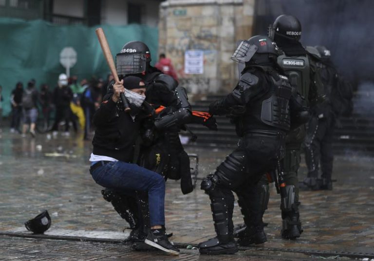 Un manifestante se enfrenta a la policía durante una protesta contra el gobierno en Bogotá, Colombia, el miércoles 5 de mayo de 2021. Las protestas que comenzaron la semana pasada por una propuesta de reforma tributaria continúan a pesar de que el presidente Iván Duque retiró el plan tributario el domingo 2 de mayo. (AP Foto/Fernando Vergara)
